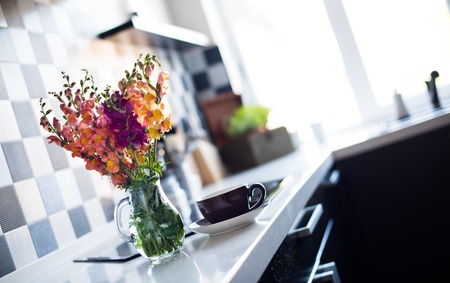 Bunch of fresh summer flowers in a jug in home interior of modern kitchen, close-upの写真素材