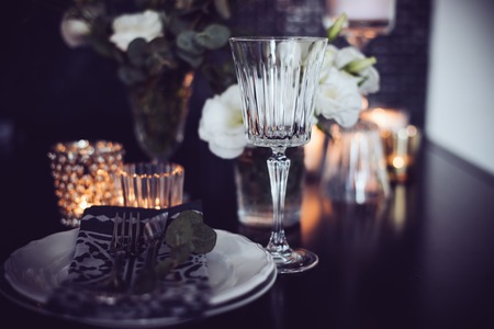 Luxury festive table setting with candles, flowers, glasses and cutlery. Table decoration for romantic dinner.の写真素材