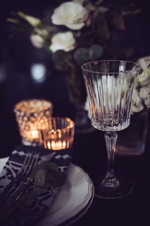Luxury festive table setting with candles, flowers, glasses and cutlery. Table decoration for romantic dinner.の写真素材