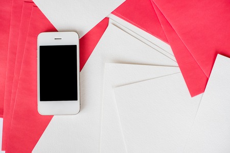 Smartphone and clean empty white and red paper sheets on office table with copy space, business and...