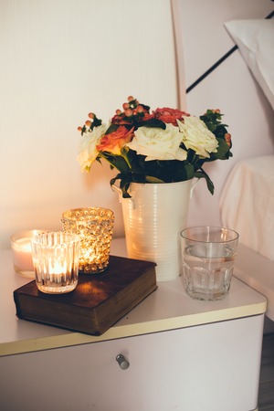 Interior of white bedroom, new linens on the bed, the room at the hotel. Bedside table decor with...