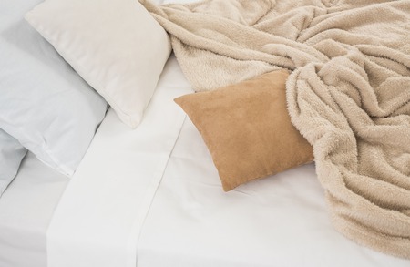 White and beige bedding, pillows and crumpled sheets, white linen cloth, abstract background.の写真素材