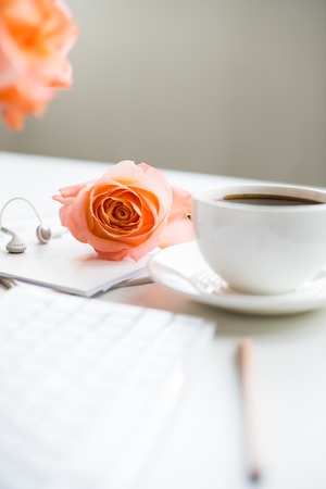 Bright white office table decor with fresh flowers, computer keyboard and smart phone. Woman's modern workspace, interior details.の写真素材