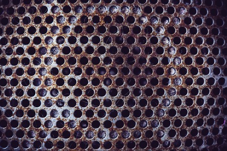 Old rusty metal texture with round holes, mucro shotの写真素材