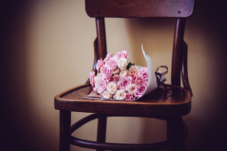 Bouquet of pink and beige roses on an old vintage chair.の写真素材
