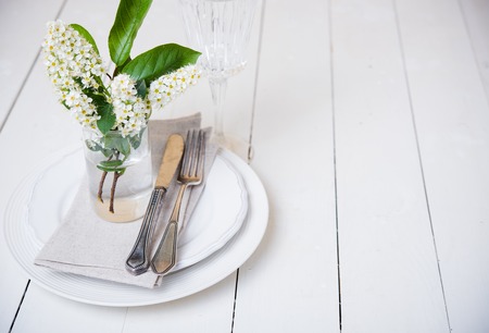 The snow white wedding table decor with bird cherry blossoms and cutlery, vintage rustic wedding table settingの写真素材