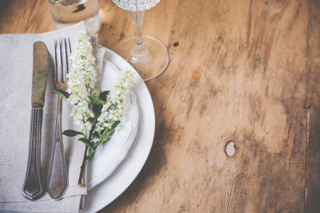 Vintage style table decor with bird cherry blossoms and old cutlery, festive rustic table settingの写真素材