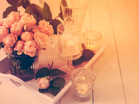 Beautiful vintage wedding table decorations with roses, candles, cutlery and  sweets in a jar.の写真素材