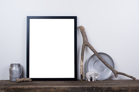 Scandinavian style empty photo poster frame mock up. Minimal home decor on rustic wooden board with...