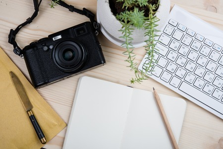 Photographers workplace tabletop, styled hipster's workspace, white computer keyboard and film camera, office desk top view with copy spaceの写真素材