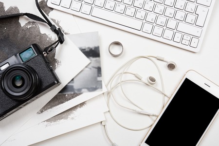 Styled tabletop with computer keyboard, smartphone and retro camera on white background, photographer artist workspaceの写真素材