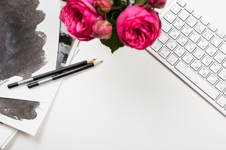 Styled tabletop mockup, computer keyboard and pink flowers on white table, freelancer girl's workspaceの写真素材