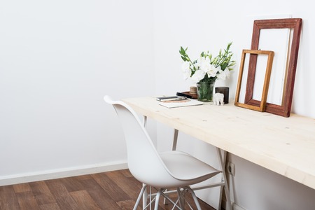 Stylish scandinavian interior design, white workspace with desk and chair, trendy artist studio decor.の写真素材