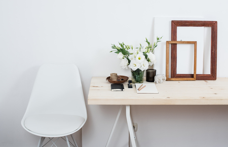 Stylish scandinavian interior design, white workspace with desk and chair, trendy artist studio decor.の写真素材