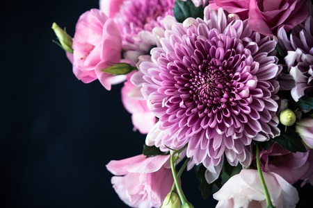 Bouquet of pink flowers closeup on black background, eustoma and chrysanthemum, elegant vintage...