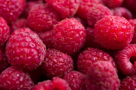 Fresh ripe raspberries macro shot, summer fruit background, vegan diet food