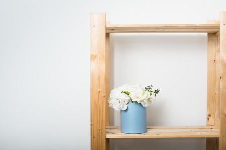 Bouquet of white hydrangeas in round  blue box on wooden shelf. Home interior decorationの写真素材