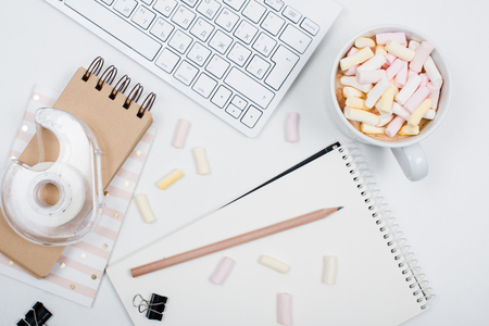 White feminine hipster workspace background, styled womans office table with coffee and marshmallows White feminine hipster workspace background, styled womans office table with coffee and marshmallows