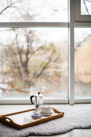 Cozy home weekend, coffee and sweets in tray on floor, warm winter indoorsの写真素材