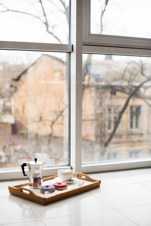 Cozy home weekend, coffee and sweets in tray on floor, warm winter indoorsの写真素材