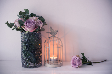 purple, mauve color fresh summer roses in vase with white wall bの写真素材