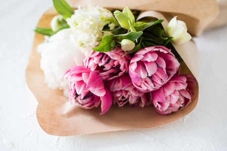 Bouquet of pink tulip flowers on table in brown paperの写真素材