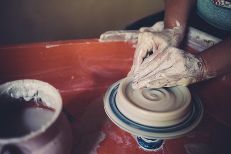 Work in a pottery workshop, womans hands creating ceramics.
