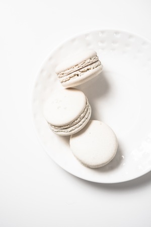 Three beige white macaroon cookies on plateの写真素材