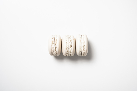 Three beige white macaroon cookiesの写真素材
