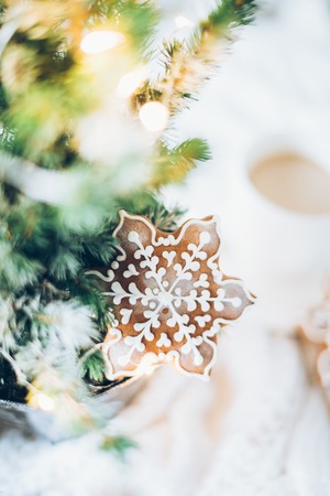 Cozy home Christmas decoration with a cup of coffee, gingerbread and white knitted blanket, new year lights bokeh closeupの写真素材