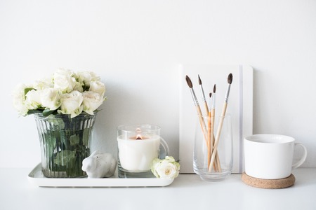 White room interior decor with burning hand-made candle and bouqの写真素材