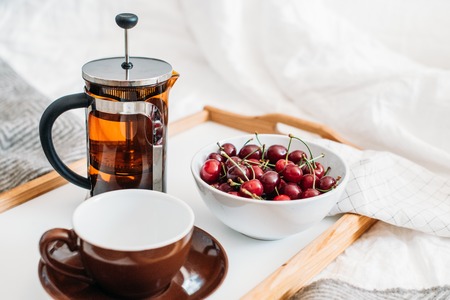 Fresh healthy vegan breakfast in bed, green tea and cherry in moの写真素材