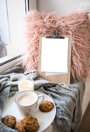 Cozy home arrangement with coffee cup and blank clipboard mockup
