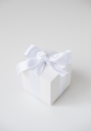 White square box with silk ribbon on white backgroundの写真素材
