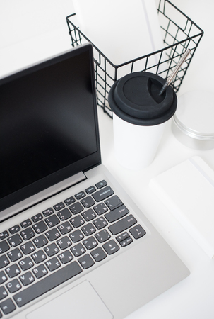 Hipster bloggers work place, laptop and flowers on white tabletopの写真素材