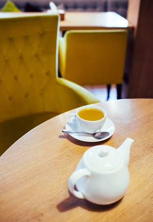 Cup of herbal tea and white ceramic teapotの写真素材