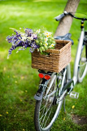 New city bicycle with bouquet of flowers in wicker basketの写真素材