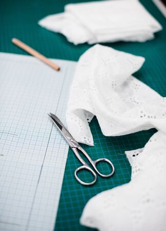 Tools, patterns and fabric samples on the sewing table in the tailor workshopの写真素材