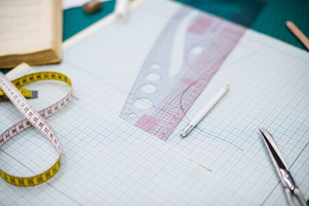Tools, patterns and fabric samples on the sewing table in the tailor workshopの写真素材