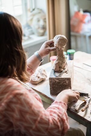 Lady sculptor working in her studio, ceramis artists handsの写真素材