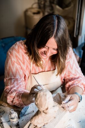Lady sculptor working in her studio, ceramis artists hands