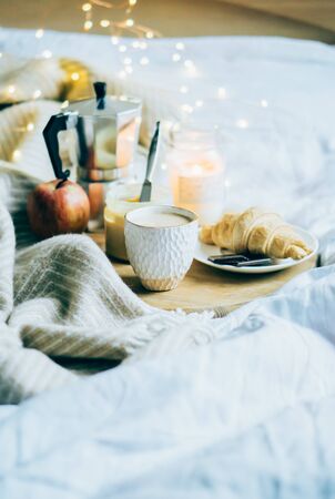 Cozy winter weekend breakfast, coffee and croissant on wooden trayの写真素材