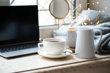 Cozy freelancers winter work place at home with cup of coffeeの写真素材