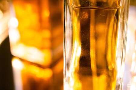 Beautiful bokeh and light reflections in yellow glass perfume bottles, abstract backgraound macro shotの写真素材