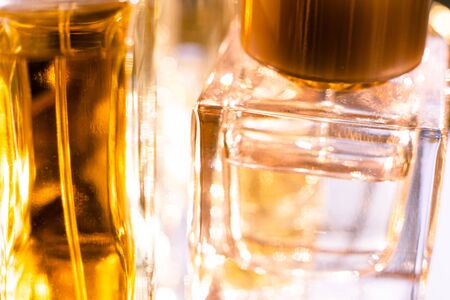 Beautiful bokeh and light reflections in yellow glass perfume bottlesの写真素材