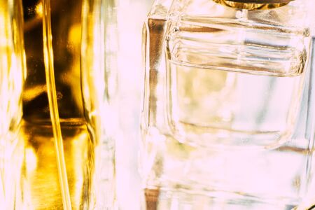 Beautiful bokeh and light reflections in yellow glass perfume bottles, abstract backgraound macro...