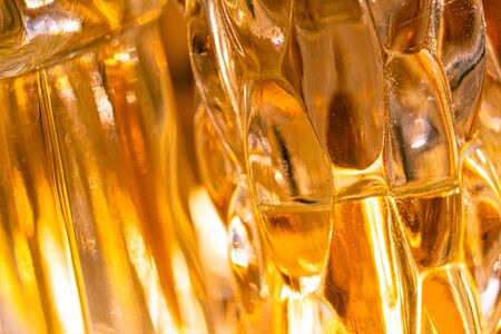 Beautiful bokeh and light reflections in yellow glass perfume bottles, abstract backgraound macro shotの写真素材