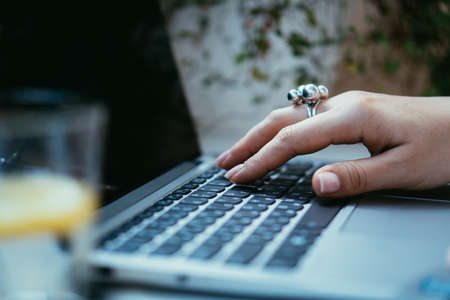 Womans hands on laptop keyboard, cozy workplaceの写真素材