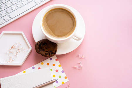 Lady bloggers home workplace, cup of coffee and laptop keyboard on pink tabletopの写真素材