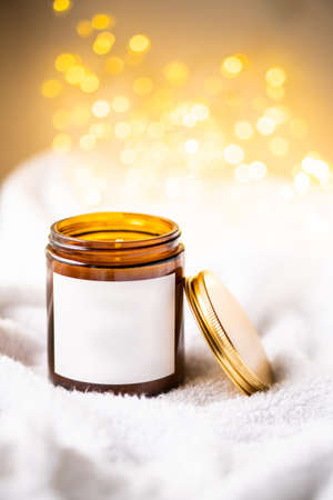 Natural wax candle in brown glass jar with metal lid and white empty clear stickerの写真素材